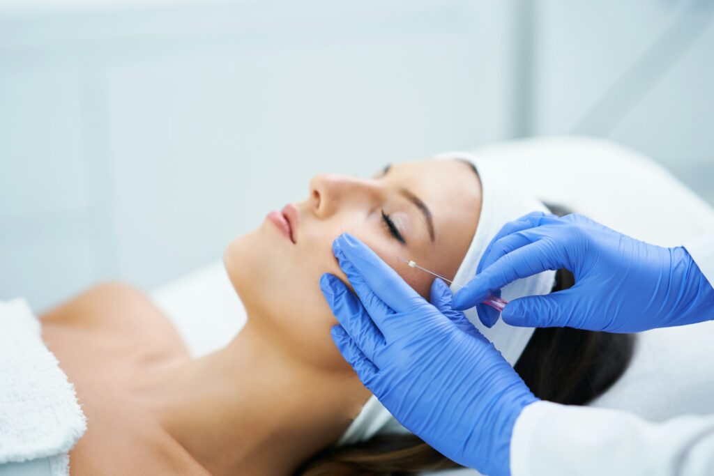 Beautiful young woman getting polydioxanone thread lifting at beauty salon.