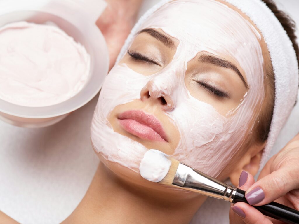 woman receiving facial mask in spa beauty salon