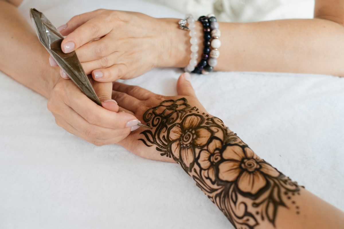 Henna tattoo on woman hands, artist drawing Arabic mehndi