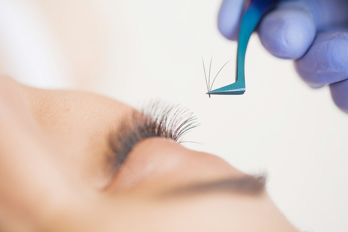 Professional stylist lengthening female lashes.